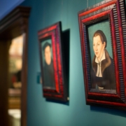 Zwei Bilder, die an der Wand im Ausstellungsraum des Museums Ludwig-Roselius in Bremen hängen. Zu sehen ist eine Frau, die das Porträt von Katharina von Bora anschaut. Im Hintergrund ist ein Porträt von Martin Luther zu sehen.