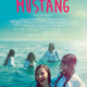 Filmplakat "Mustang". Fünf junge Frauen schwimmen lachend mit Schulkleidung bekleidet im Meer.