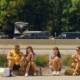 Filmausschnitt von vier Personen, die an Straßenrand sitzen
